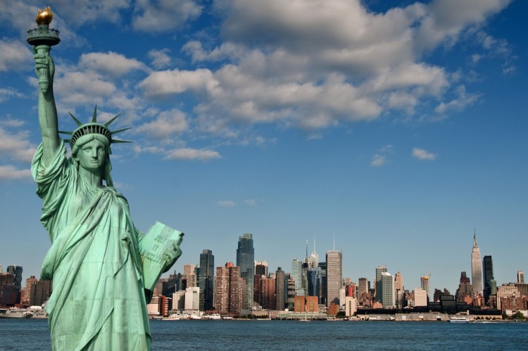 statue of liberty with her tablet with Manhattan in background